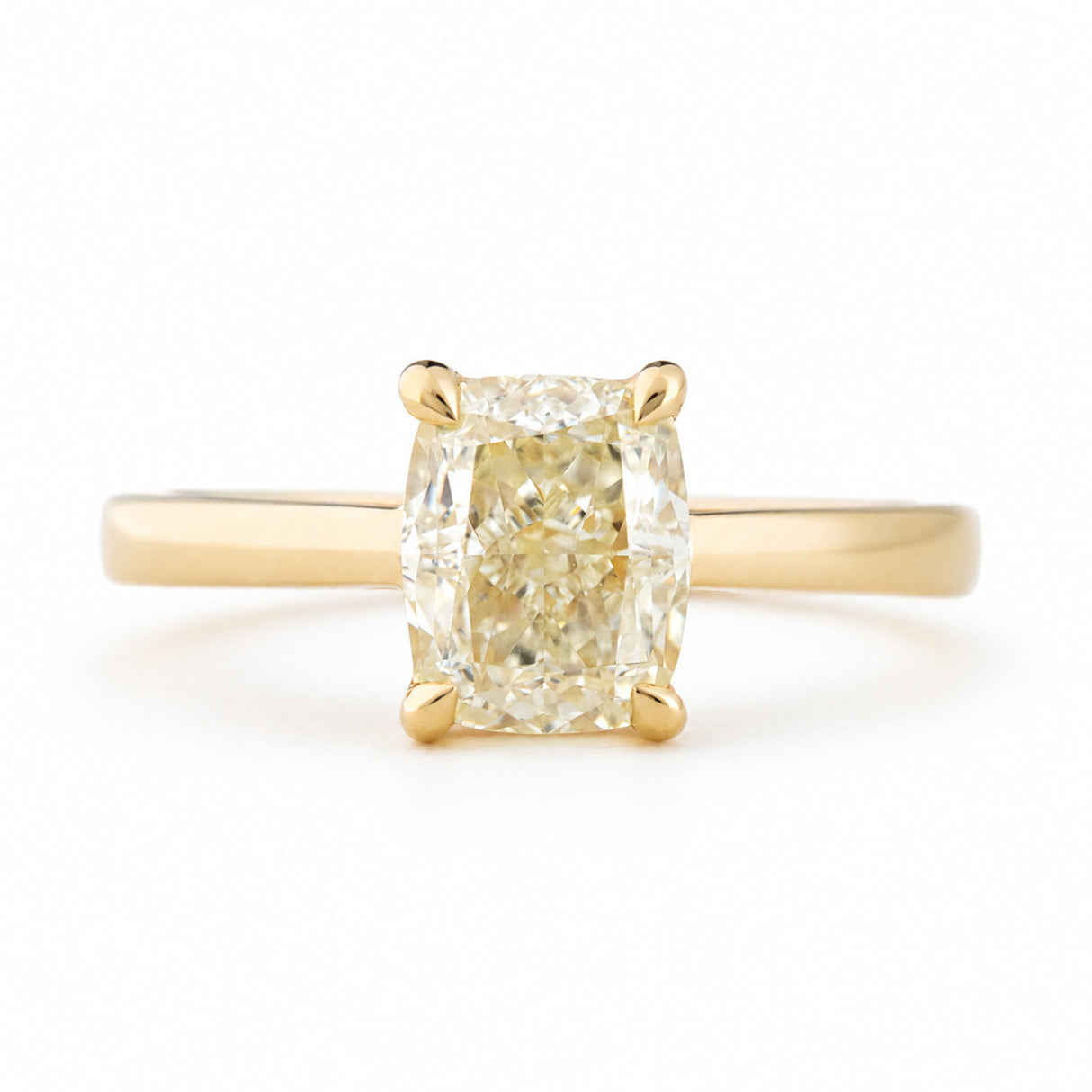 Antique-inspired, cushion-cut diamond solitaire engagement ring in yellow gold against a white background