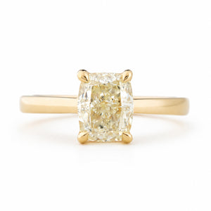 Antique-inspired, cushion-cut diamond solitaire engagement ring in yellow gold against a white background