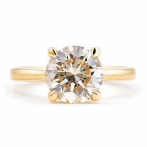 Antique-inspired, Light brown diamond solitaire engagement ring against white background