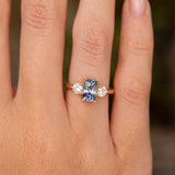 Close-up of an antique-inspired cushion-cut blue sapphire and diamond engagement ring in yellow gold.