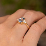 Vintage-inspired sapphire and diamond engagement ring worn on the hand, featuring an open 14ct yellow gold setting.