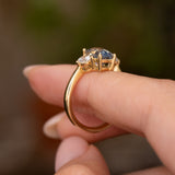Antique-inspired sapphire and diamond engagement ring showing its sculptural open setting and polished 14ct yellow gold band.