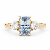 Antique-inspired three-stone engagement ring with a cushion-cut blue sapphire and round brilliant-cut diamonds in 14ct yellow gold.