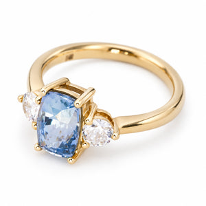 Vintage-inspired blue sapphire and diamond three-stone engagement ring with a polished 14ct yellow gold band.