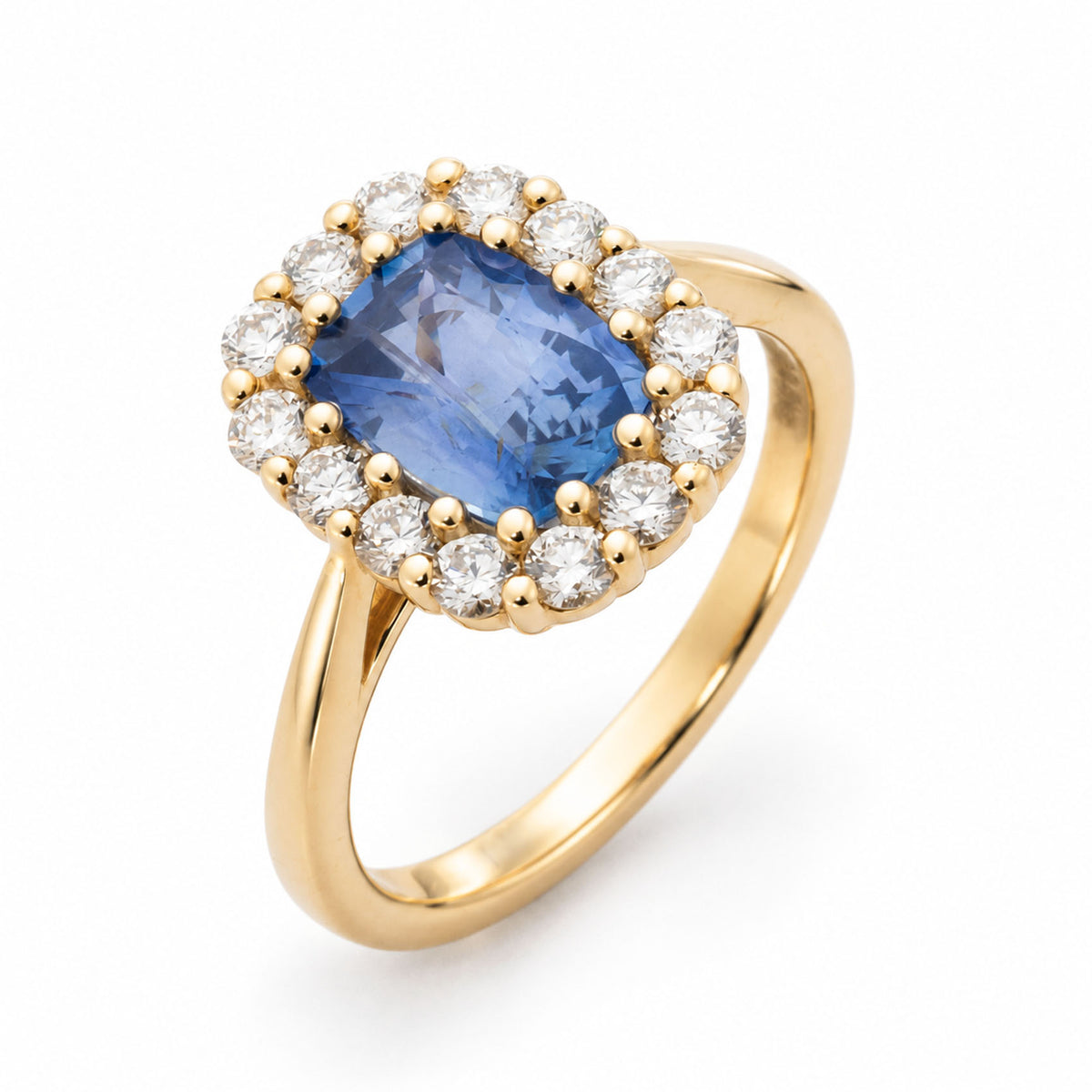 Angled product view of a vintage-inspired blue sapphire and diamond cluster ring, featuring a cushion-cut centre stone in polished 14ct yellow gold.