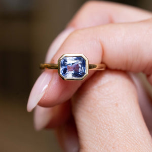 Close detail of an antique-inspired blue sapphire solitaire ring crafted in yellow gold.