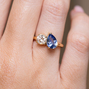 Sapphire and diamond Toi et Moi engagement ring worn on the finger