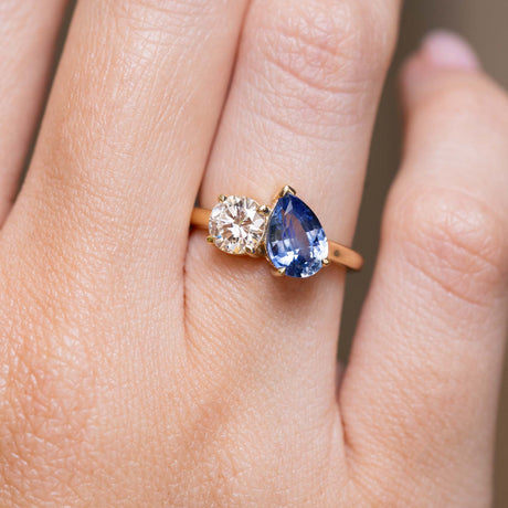 Sapphire and diamond Toi et Moi engagement ring worn on the finger