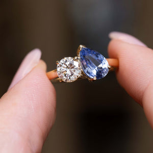 Close-up of a pear-cut sapphire and round diamond Toi et Moi ring