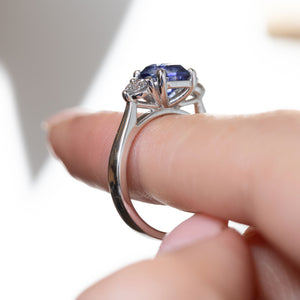Side profile of the antique-inspired three-stone engagement ring, revealing the intricate openwork gallery and elegant platinum band.