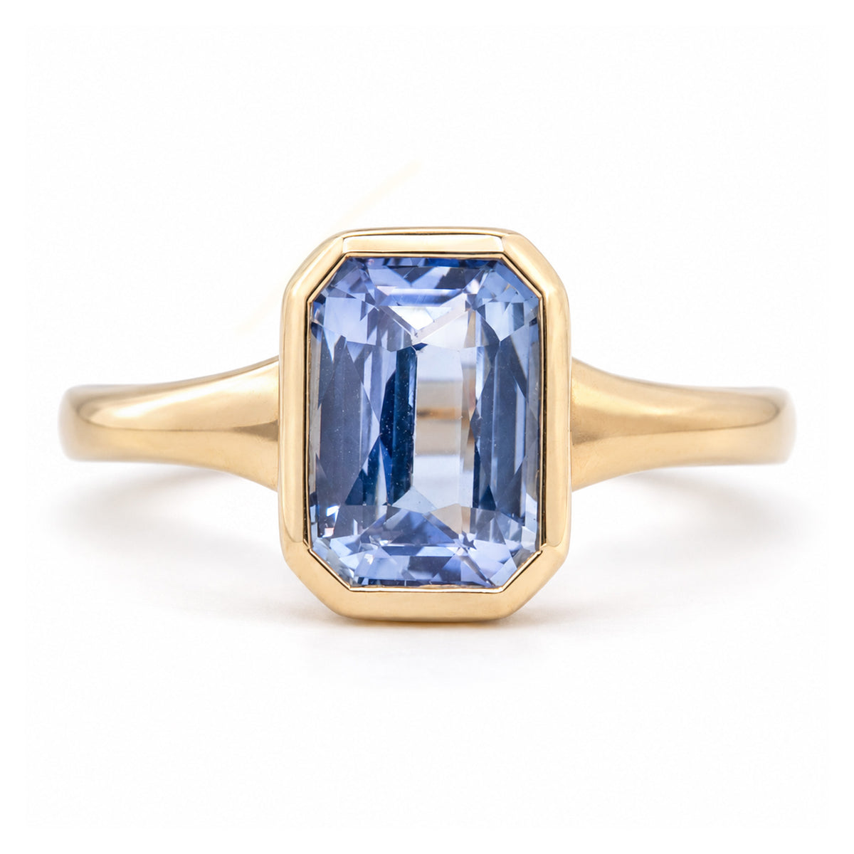 Antique-inspired sky-blue sapphire solitaire ring in yellow gold, featuring a rectangular gemstone in a smooth rub-over setting.