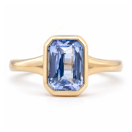 Antique-inspired sky-blue sapphire solitaire ring in yellow gold, featuring a rectangular gemstone in a smooth rub-over setting.