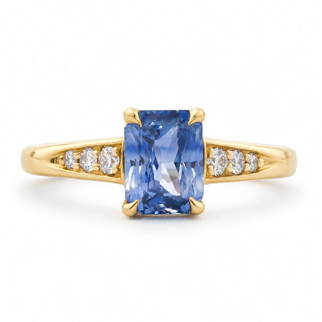 A vintage-inspired, blue sapphire and diamond flanked solitaire engagement ring set in 14ct yellow gold. 