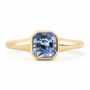 An antique-inspired, pale blue sapphire  set in a rub-over setting in yellow gold.
