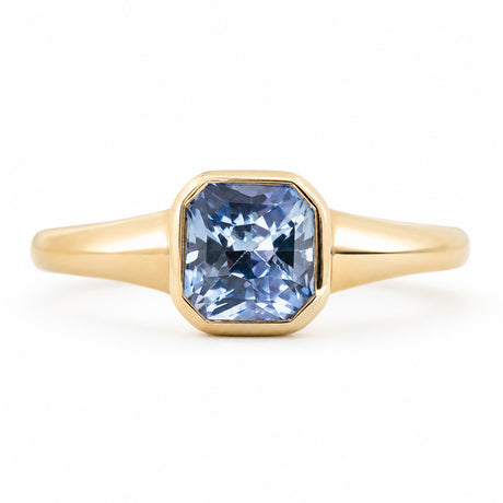 An antique-inspired, pale blue sapphire  set in a rub-over setting in yellow gold.