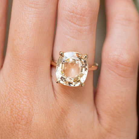 A close-up of a hand wearing an Antique-inspired, Yellow sapphire solitaire engagement ring gold ring 