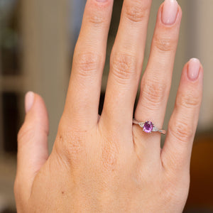 Antique-inspired sapphire and diamond engagement ring worn on the hand, showcasing its colourful three-stone platinum setting.