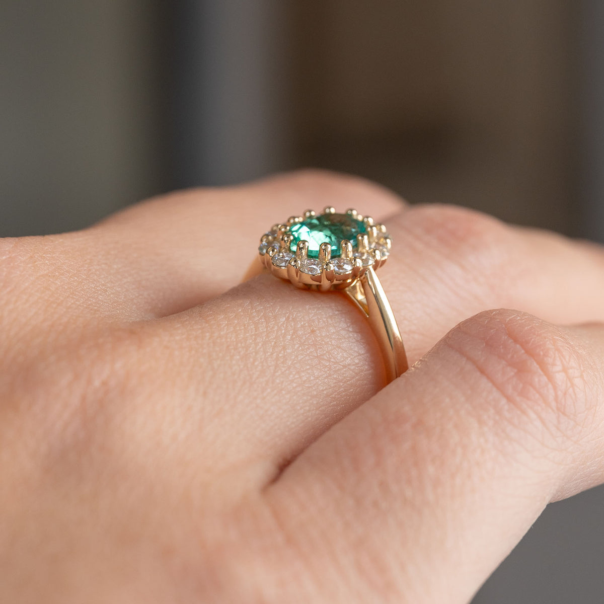 Low side angle of the antique-inspired ring being worn, revealing the raised cluster and slender yellow gold shank.