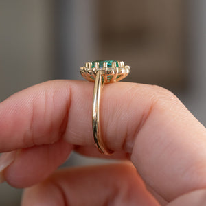 Profile view of the emerald cluster ring, displaying the elevated gallery, claw settings and polished yellow gold band.