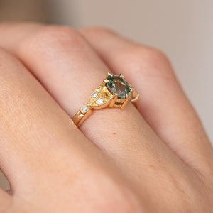Side angle on the hand revealing the raised sapphire setting, openwork shoulders and fine beaded detailing.