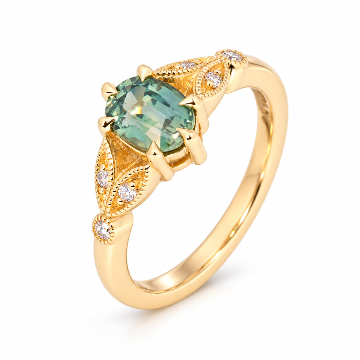 Three-quarter studio view of the teal sapphire ring, showcasing its sculptural gold setting and delicate vintage-style detailing.