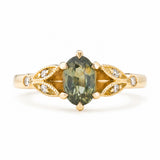 Vintage-inspired, Green sapphire and diamond engagement ring against a plain white background