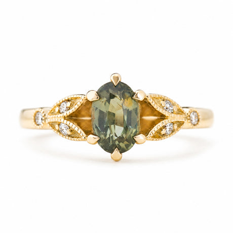 Vintage-inspired, Green sapphire and diamond engagement ring against a plain white background