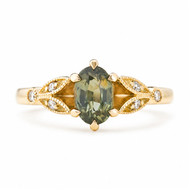 Vintage-inspired, Green sapphire and diamond engagement ring against a plain white background