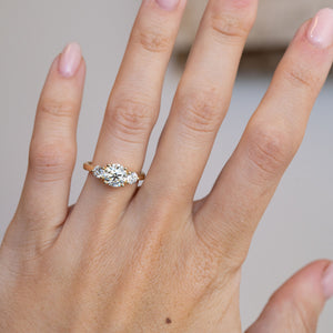 Pale yellow diamond three-stone engagement ring worn on a hand, showcasing its elegant proportions.