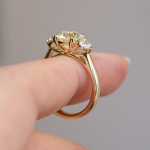 Side profile of the antique-inspired diamond ring, revealing its openwork gallery and polished yellow gold band.
