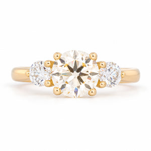 Antique-inspired pale yellow oval diamond three-stone engagement ring in yellow gold, front view.