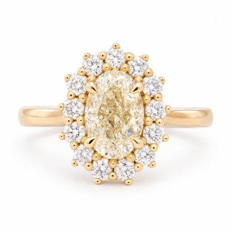Antique-inspired yellow oval diamond cluster engagement ring surrounded by brilliant-cut white diamonds in yellow gold, front view.