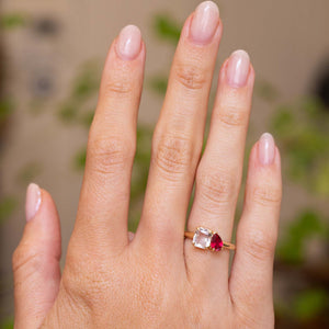 a hand wearing a yellow gold Antique-inspired, Pink sapphire and spinel Toi et Moi engagement ring