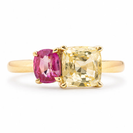 an Antique-inspired, Yellow and pink sapphire Toi et Moi engagement ring in yellow gold against a plain white background