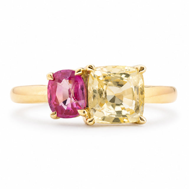an Antique-inspired, Yellow and pink sapphire Toi et Moi engagement ring in yellow gold against a plain white background