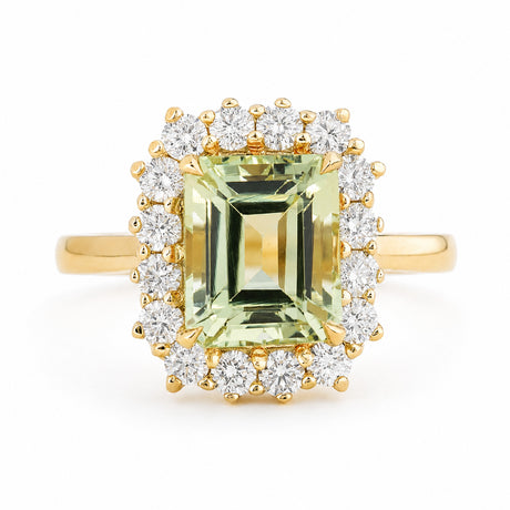 A Vintage-inspired, yellow gold halo engagement ring featuring a large emerald-cut light green beryl surrounded by a row of diamonds, set against a plain white background.