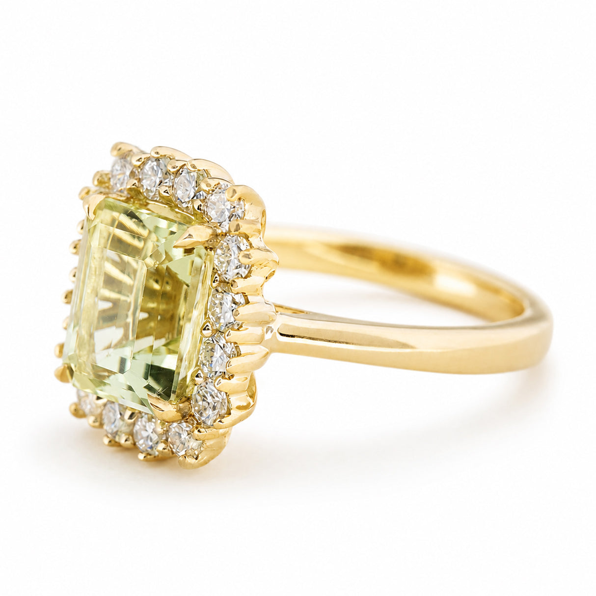 A side profile photo of an Antique-inspired, Green beryl and diamond cluster engagement ring.  Showcasing the yellow gold band and setting of the central stone and diamonds, shown on a clean white background.