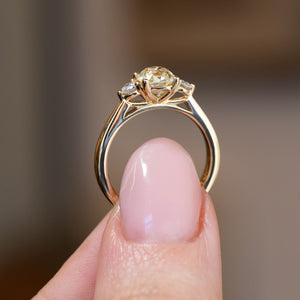 Side profile of the antique-inspired three-stone ring, revealing the openwork gallery and elegant yellow gold band.