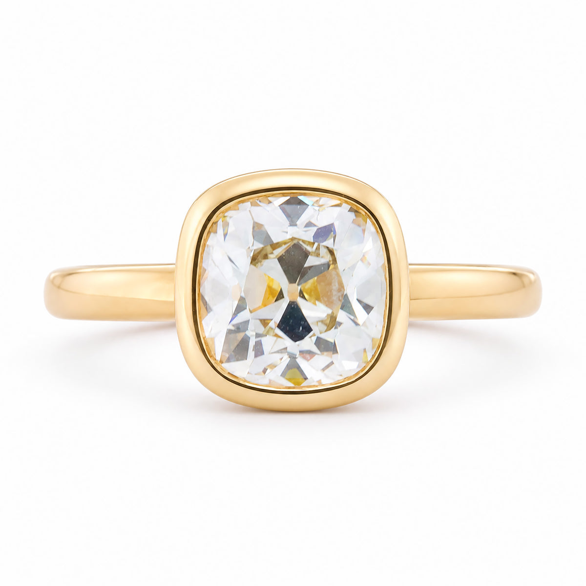 Front view of an antique-inspired yellow-tinted cushion old-mine cut diamond solitaire engagement ring in polished yellow gold.
