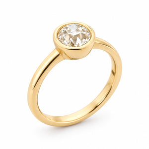 A three-quarter view of an vintage inspired yellow gold solitaire engagement ring, set with an old-cut diamond.
