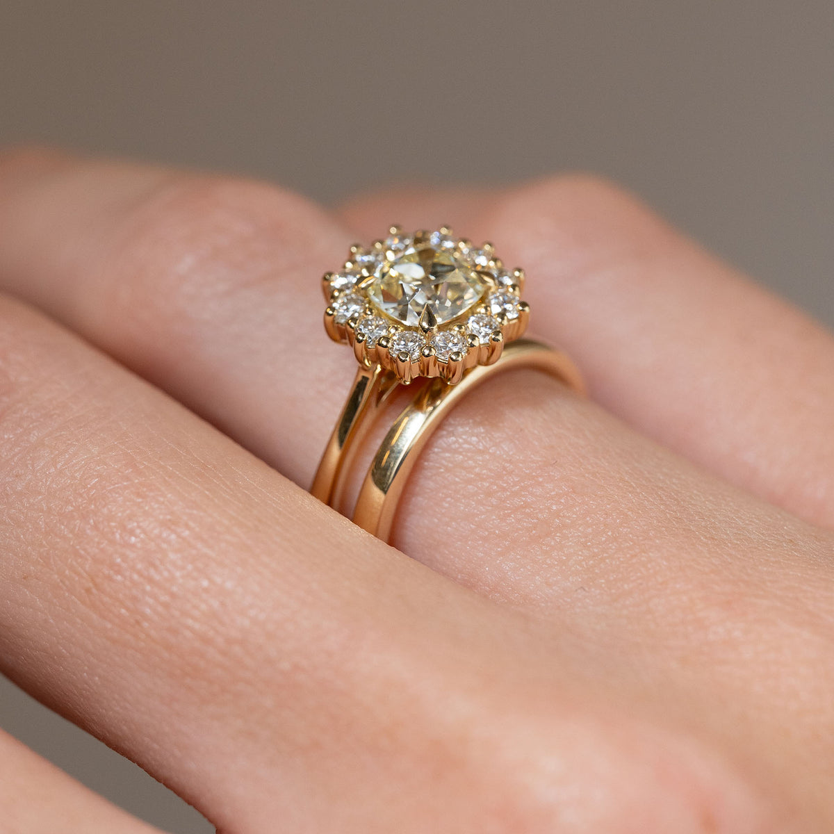 Side-angle view of the yellow diamond cluster engagement ring paired with a wedding band, showcasing its wed-fit design for a flush-fitting wedding ring.
