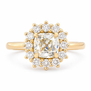 Antique-inspired yellow cushion old-mine cut diamond cluster engagement ring in yellow gold, surrounded by a halo of brilliant-cut white diamonds.