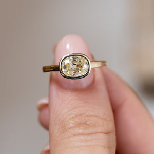 Hand-held close-up of the old mine-cut diamond, showcasing its antique-style faceting and elegant bezel setting.