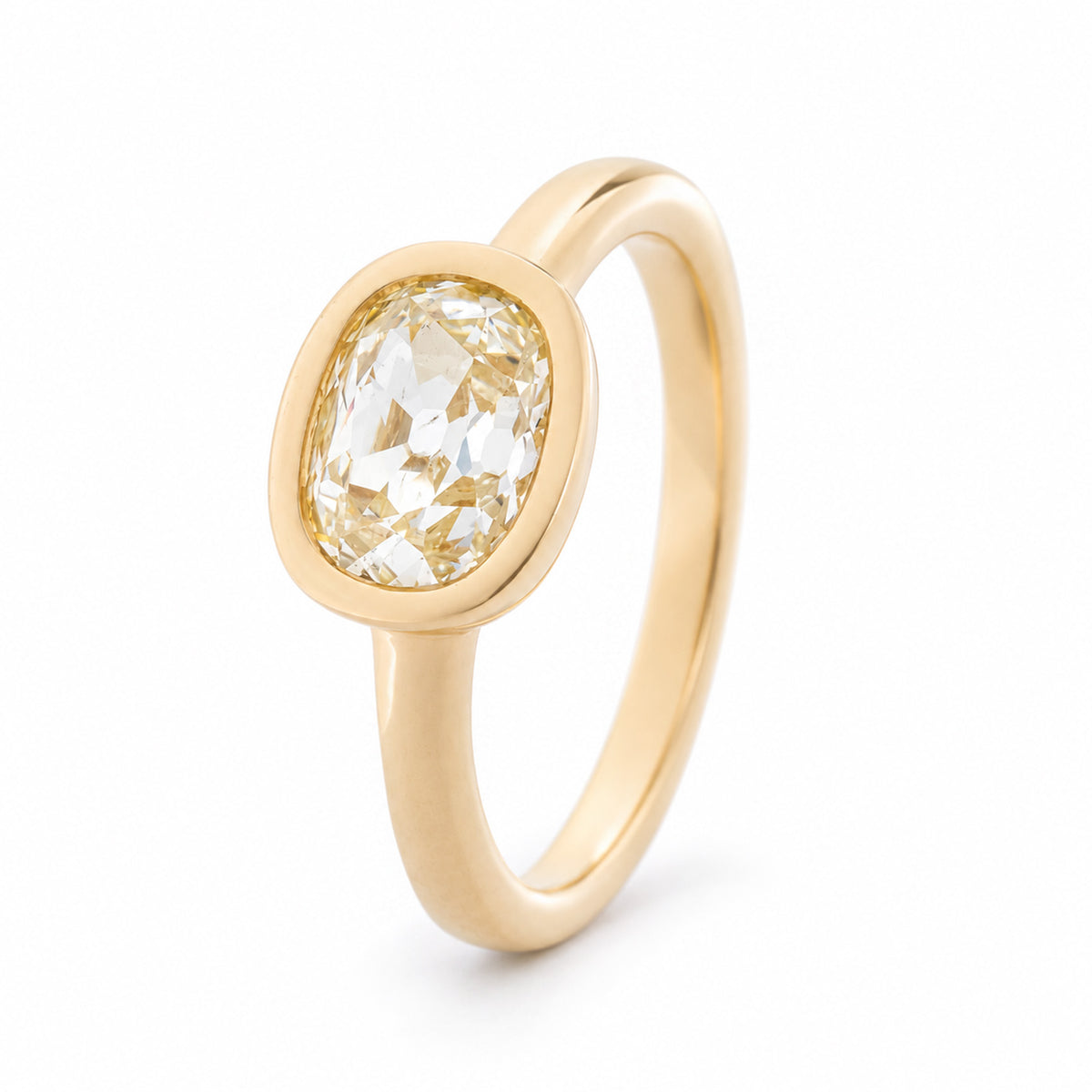Angled view of the old mine-cut diamond ring, highlighting the smooth yellow gold bezel and elegant solitaire design.