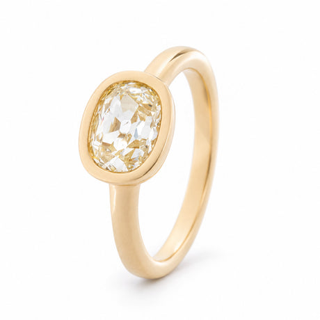Angled view of the old mine-cut diamond ring, highlighting the smooth yellow gold bezel and elegant solitaire design.