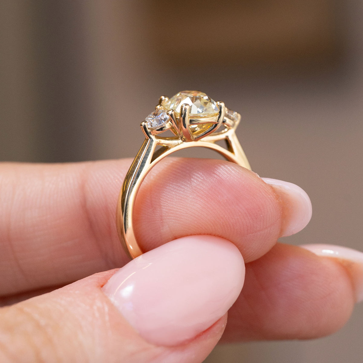 Underside profile displaying the sculpted gallery and slender yellow gold shank of the three stone engagement ring.