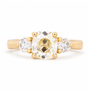 Antique-inspired old-mine diamond three-stone engagement ring in yellow gold.