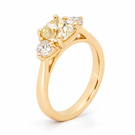 Raised studio view highlighting the three claw-set diamonds and polished gold band.