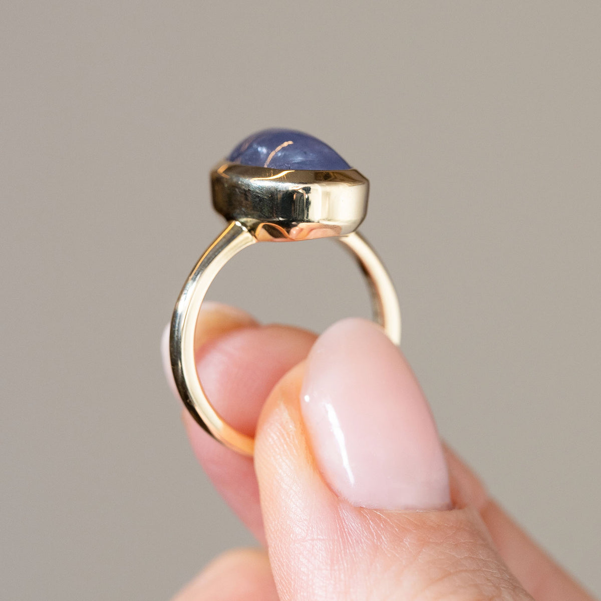 Side profile of the antique-inspired gold ring, revealing the domed sapphire, elevated bezel and simple polished band.