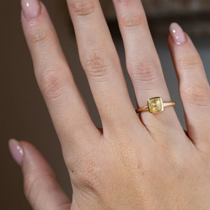 Antique-inspired cushion-cut yellow sapphire ring worn on a hand, highlighting its warm golden tones and elegant solitaire design.